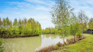 A calm river with trees and a grassy bank. - New in 2018. Modern and luxurious lodge with lakeside view. (Woodhall Spa)