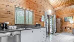 A wooden cabin kitchen with a Bosch dishwasher, a sink, and a window with blinds. - 2 bedroom accommodation in Freehay, Cheadle (Freehay, Cheadle)