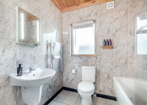 Une salle de bain avec un lavabo, des toilettes et une baignoire.