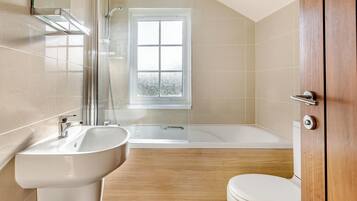 Une salle de bain avec un lavabo, des toilettes et une baignoire.