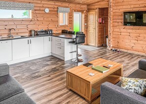 Ein Holzinnenraum mit Küche, Essbereich und Wohnzimmer.
