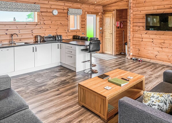Un intérieur en bois comprenant une cuisine, un coin repas et un salon.