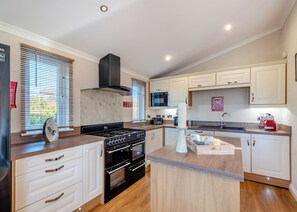 A modern kitchen with a stove, oven, microwave, and a sign indicating a wine glass and wine bottle.