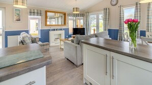 A modern kitchen with a built-in oven, a dining area with a sofa, and a living room with a television. - 2 bedroom accommodation in Swinethorpe, Nr Lincoln (Swinethorpe, Nr Lincoln)