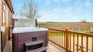 A hot tub on a wooden deck with a view of a field. - 2 bedroom accommodation in Swinethorpe, Nr Lincoln (Swinethorpe, Nr Lincoln)
