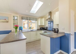 A kitchen with a central island, a window with a view, and a built-in microwave.