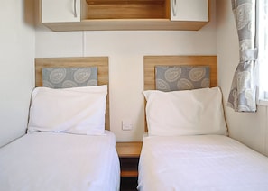 Ein Doppelzimmer mit Kopfteil und einer kleinen Holzablage darüber.