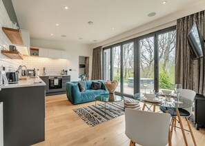 Een moderne woonruimte met keuken, eethoek en grote ramen.