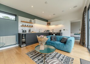 Une cuisine moderne avec des carreaux blancs, un canapé bleu et une table basse en verre.