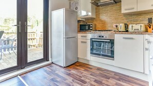 A modern kitchen with a refrigerator, microwave, oven, and toaster. - Kingfisher Lakeside Lodge (Caerwys, Flintshire)