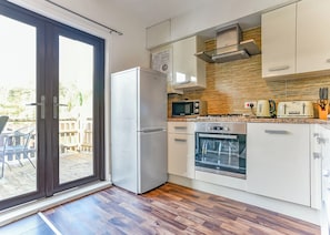 A modern kitchen with a refrigerator, microwave, oven, and toaster. - Kingfisher Lakeside Lodge (Caerwys, Flintshire)