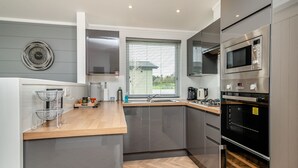 A modern kitchen with a built-in microwave, oven, and sink.