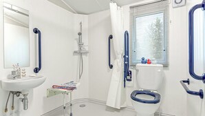 Un bagno moderno con lavandino, water e doccia bianchi.
