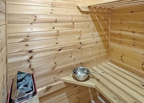 A sauna room with wooden walls and a metal basin. - Cottage with one double and two twin. (St Clears)