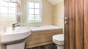 Un baño con bañera, lavabo e inodoro.