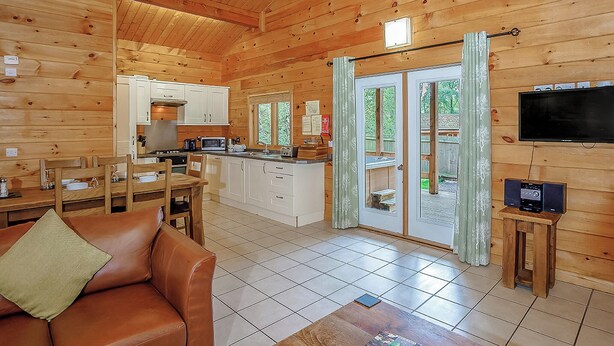 L’intérieur d’une cabane en bois comprend un coin repas, une cuisine et un téléviseur.