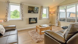 Una sala de estar con sofá, mesa de centro, televisor y chimenea.
