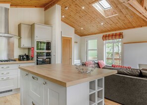 A modern kitchen with white cabinets, a wooden countertop, and a built-in oven. - 3 bedroom accommodation in Freehay, Cheadle (Freehay, Cheadle)