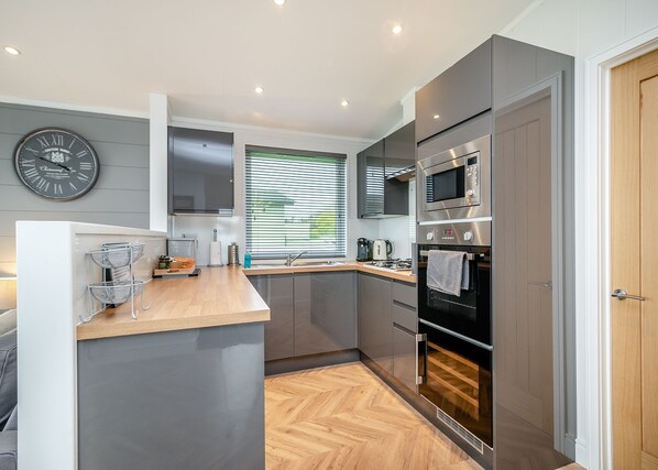 A modern kitchen with a built-in oven, a microwave, and a sink.