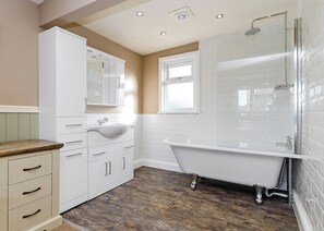Un baño con una bañera independiente, un lavabo y un mueble con cajones.