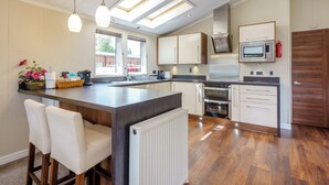 Une cuisine moderne dotée d’un îlot central, d’appareils électroménagers intégrés et d’une lucarne.