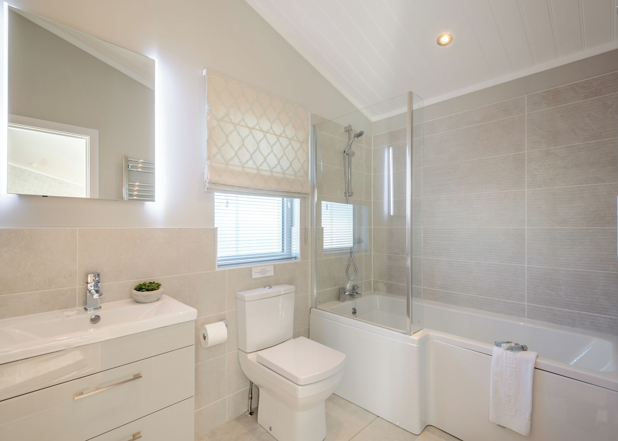 Une salle de bain moderne équipée de toilettes, d’un lavabo et d’un espace douche.