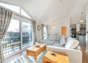 A modern living room with a sofa, coffee table, and dining area.