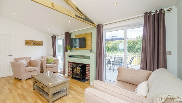 A living room with a fireplace, sofas, a coffee table, and a TV mounted on the wall.