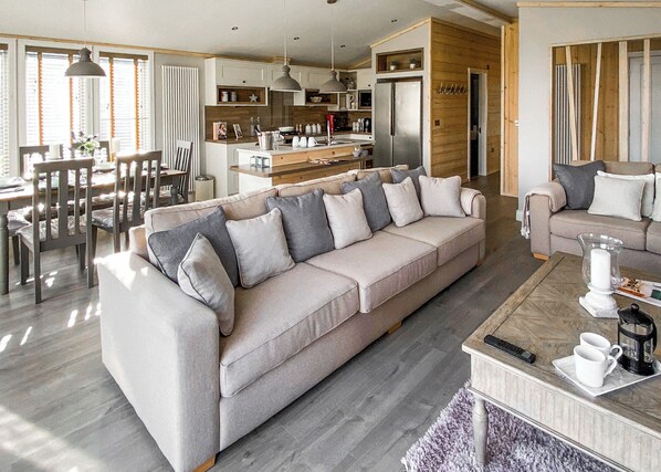 Ein modernes Wohnzimmer mit Sofa, Couchtisch und Essbereich.