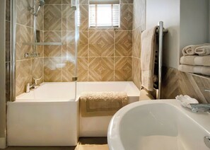 A bathroom with a bathtub, a shower, and a sink.