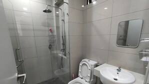 A modern bathroom with a glass-enclosed shower, a toilet, and a sink. - Suasana Damai (Petaling Jaya)