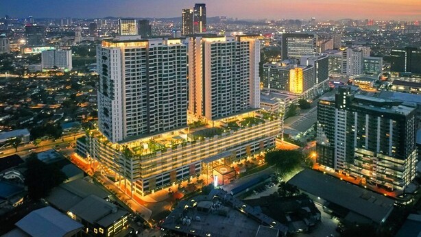 A high-rise building complex with multiple floors, surrounded by other buildings and a cityscape at dusk. - Suasana Damai (Petaling Jaya)