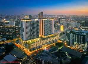 A high-rise building complex with multiple floors, surrounded by other buildings and a cityscape at dusk. - Suasana Damai (Petaling Jaya)
