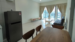 A modern living room with a dining table, chairs, a sofa, and a large window with curtains. - Suasana Damai (Petaling Jaya)