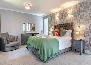 A bedroom with a bed, nightstands, a chair, a dresser, and a mirror.