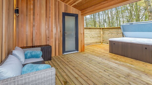 A wooden deck with a sofa and a hot tub. - 1 bedroom accommodation in Haddon (Haddon)