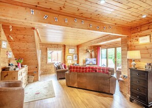 L’intérieur d’un chalet confortable, avec un canapé, un téléviseur et des murs en bois.