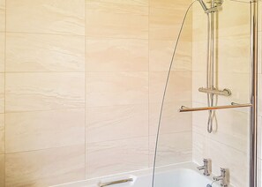 Un baño con ducha, bañera y retrete.