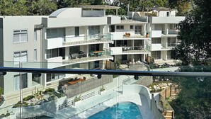 A multi-story residential building with a swimming pool and outdoor seating areas. - Penthouse 23 - The Cove (Noosa)