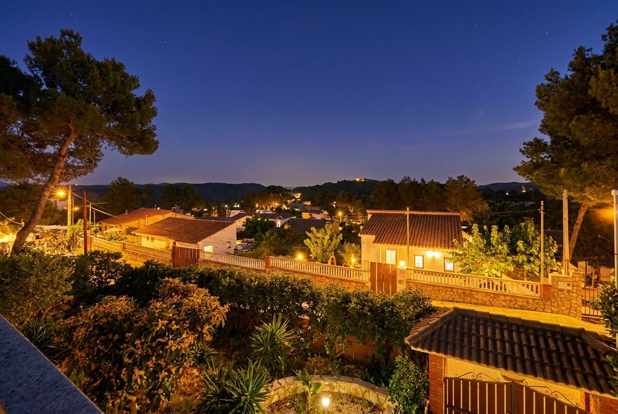 A residential area with houses, a stone bridge, and a clear night sky.