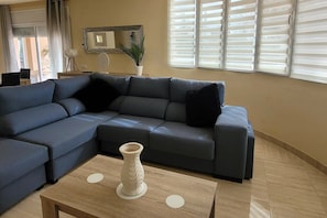 Relax in this stylish living room with a sofa, framed mirror, and potted plant.