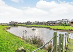 A pond with houses in the background.
