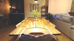 A wooden dining table with a bench, a sofa, and a bookshelf in a cozy living room. - Casa Rural El Ojuelo (VTAR) (El Ojuelo)