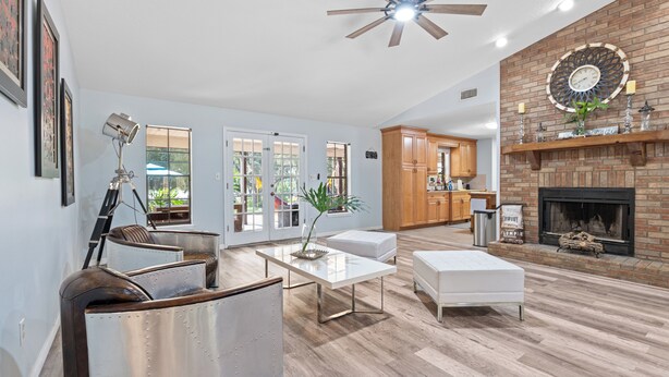 A spacious living room with a fireplace, a dining area, and a kitchen. - Ranch with pool/Lake fishing kayak Paddleboard Soccer Motocross 30 min to Disney (Clermont)