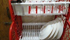 A red and white dish rack with multiple plates and a knife. - Nicely 3 bedrooms apartment at Mohammadpur (Dhaka)