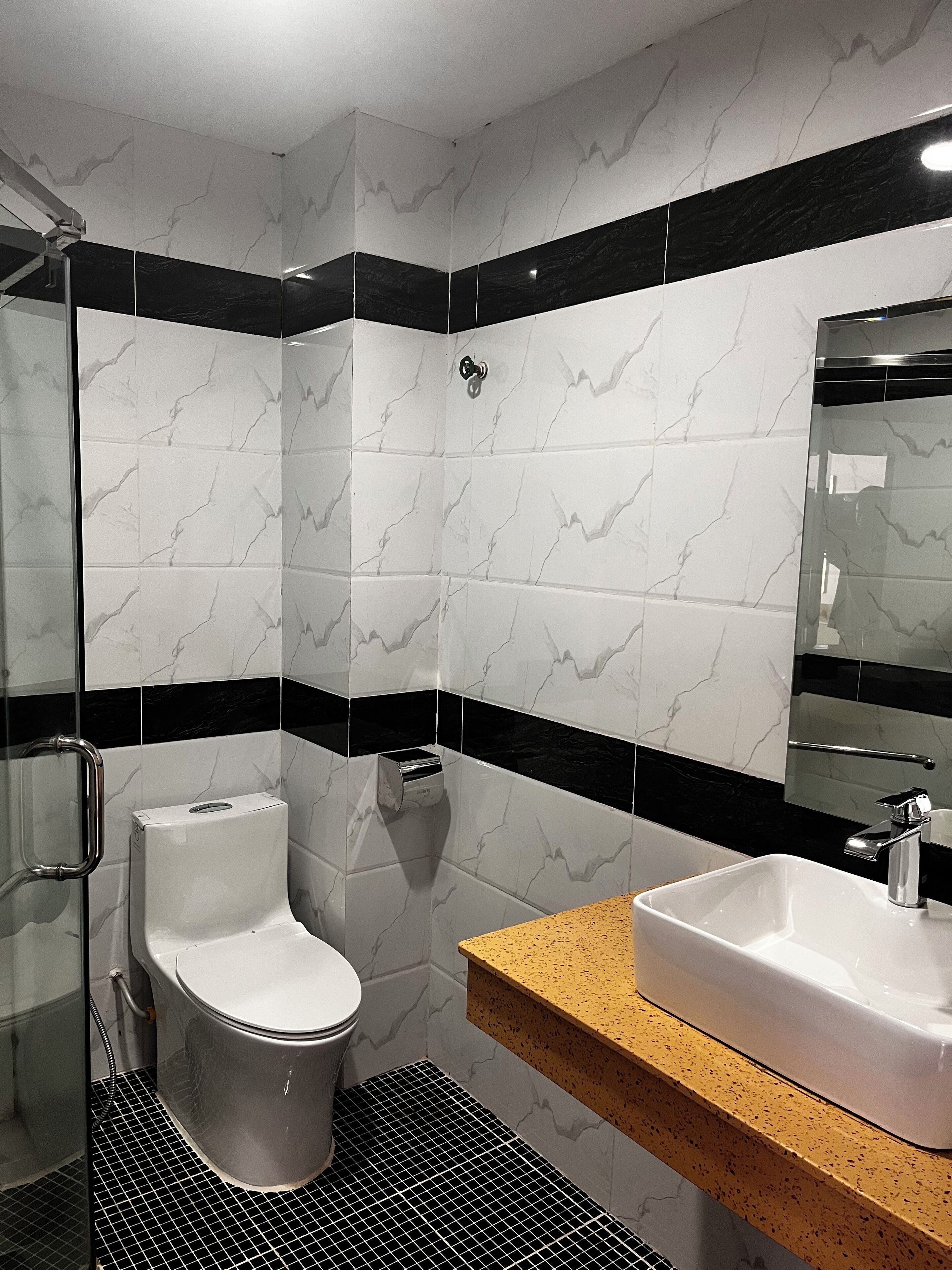 A modern bathroom with a toilet, sink, and shower.