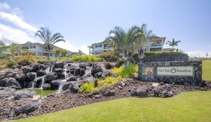 Experience the serene surroundings of Na'alehu Keauhou, where lush greenery and a natural waterfall create a tranquil atmosphere.