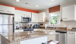 Enjoy cooking in this well-equipped kitchen with a refrigerator, microwave, stove, and dishwasher, and take in the view from the window.