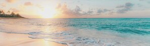 A beach with calm waters and a sunset. - Mallacoota Hotel Motel (Mallacoota)