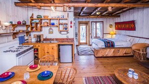 Un chalet confortable doté d’une cuisine, d’un coin repas et d’un lit offrant une vue agréable.